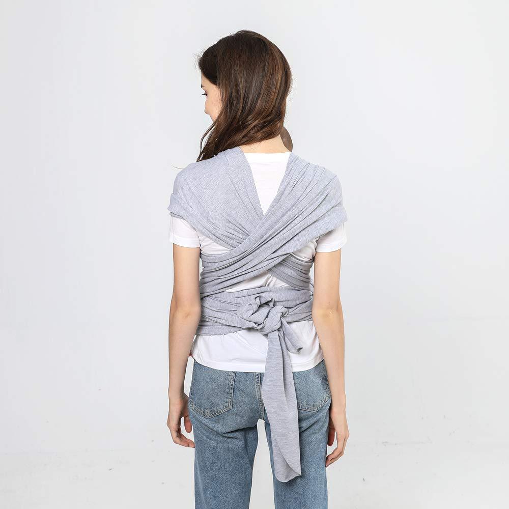 Person wearing a gray wrap carrier on a plain background