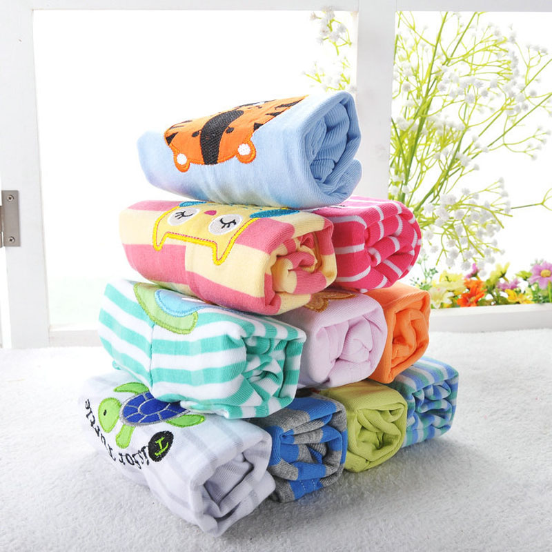 Stack of colorful folded towels with cartoon designs on a light surface.