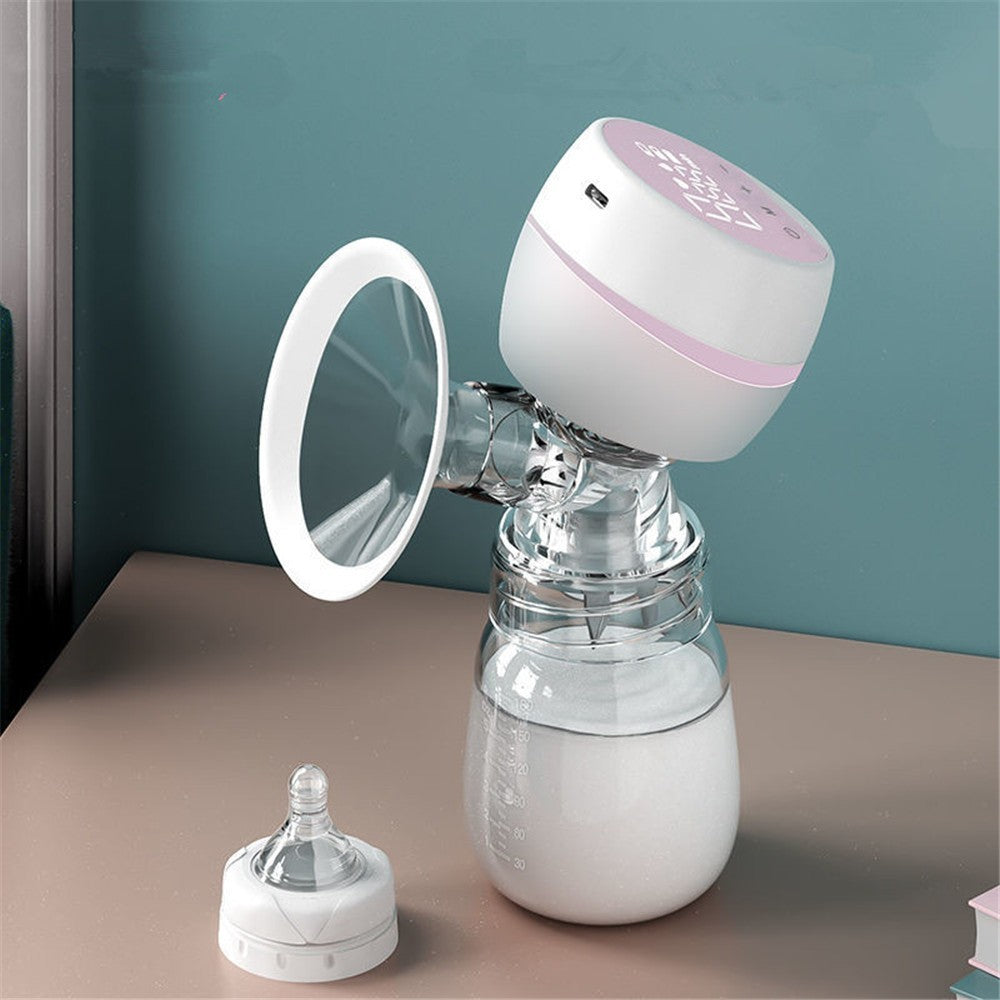 Breast pump with a bottle and additional parts on a surface against a teal wall.